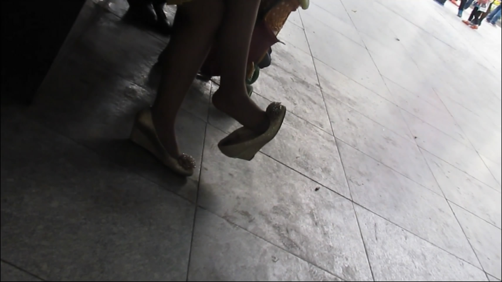 Pretty lady&#039;s foot dangle on high heel shoe in the public.